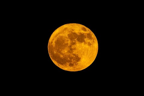 Full moon in the night sky in a warm orange-coloured light, full moon, flower moon,