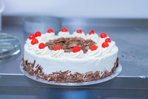 Round cream cake with cherries and chocolate on a table, cake baking, Haselstaller Hof Cafe Kuh,