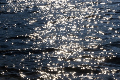 Sunbeams reflect glittering on water surface with high waves, Abstract background, Graphic