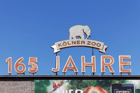 Cologne Zoo 165 years, anniversary sign covered with fabric in front of a blue sky, Cologne, North