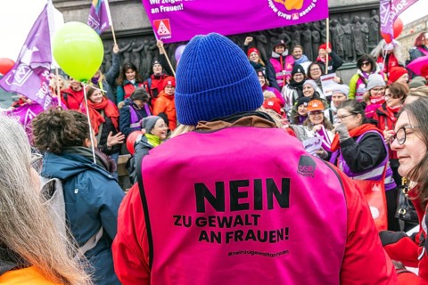 DGB woman proclaim international solidarity at a trade union rally. The trade unionists wear purple
