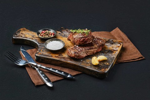 Pan seared juicy beef steak on dark background