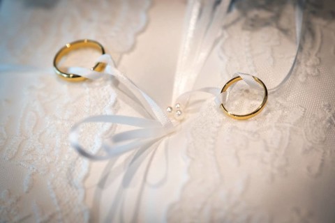 Wedding rings on an ornate white cushion