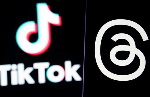 Threads logo is seen on a smartphone and Tiktok logo in the background