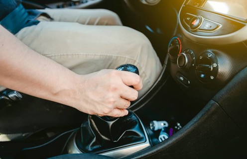 Close up of hand accelerating on gear stick. Close-up of driver hand on the gear lever of a car,