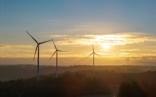 Sunrise with wind turbines in a wooded hilly landscape, Rems Valley, Baden-Württemberg, Germany