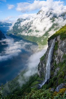 Gjerdefossen waterfall, at Ørnesvingen viewpoint, atmospheric clouds over the fjord in the morning