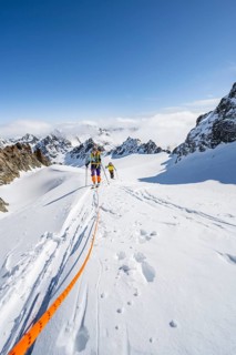 Ski tourer with rope, rope team on the Vadret da Porchabella glacier on the ascent to the summit of