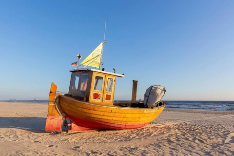Traditional wooden fishing boat on the beach along the Baltic Sea at Ahlbeck, Heringsdorf on the