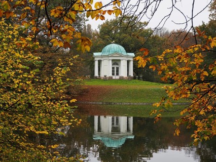 Temple on the Swan Island in the Karlsaue, surrounded by autumnal trees, whose reflection can be