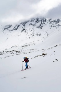 Ski tourers in a wintry mountain landscape with cloudy mountain peaks, ascent to Piz Laviner,
