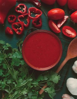 Tomato sauce, tomatoes and sweet pepper, Georgian Satsebeli sauce, with ingredients on a dark