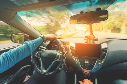 View of the driver hands driving on the highway. Driver hands on the steering wheel while driving