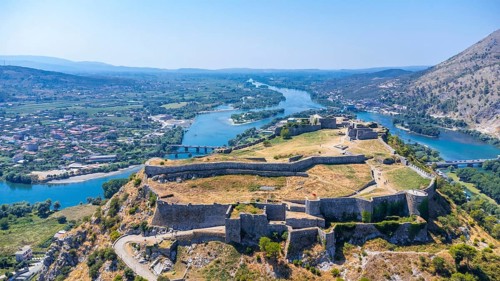 Aerial drone view of Rozafa Castle in the city Shkoder and its walls next to the lake and the river