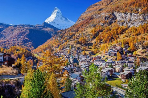 View of the village with Matterhorn 4478m and golden yellow larches in autumn, Zermatt, Mattertal,