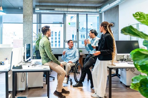 Businesspeople having a conversation in a modern office, demonstrating inclusion and teamwork with