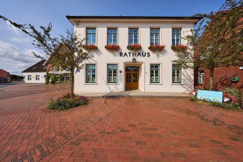 Town hall, flagpoles, blue sky, Ohrbült street, Zetel, district of Friesland, Lower Saxony, Germany