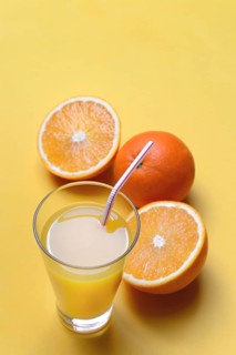 Orange juice in glass and oranges