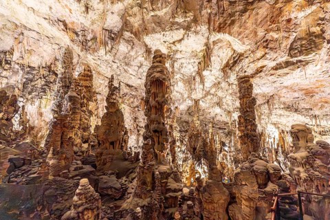 Tourists marveling at the magnificent formations of stalactites and stalagmites inside postojna