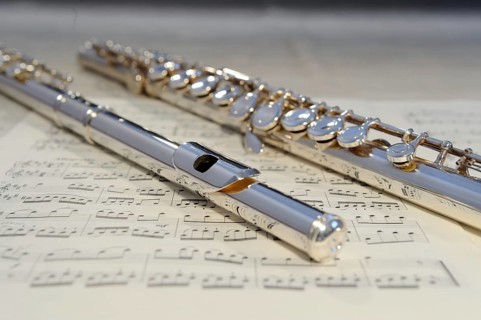 Silver flute lying on a sheet of music