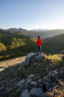 Mountaineer in front of mountain landscape at sunrise, view of mountain peaks of the Venediger