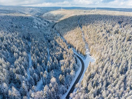 Aerial view of a snow-covered forest with a lonely road, winter tranquillity, Bad Wildbad, district
