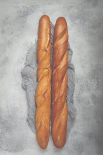 Fresh French baguette, two pieces, top view, on the table, no people