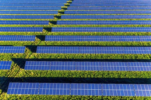 Aerial view over blue solar panels of photovoltaic power station, solar park for the supply of