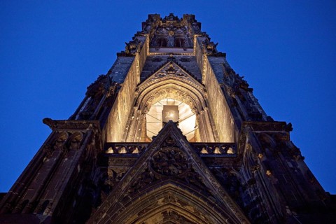 Illuminated church tower of the St. Nikolai memorial, ruins of the former main church of St.