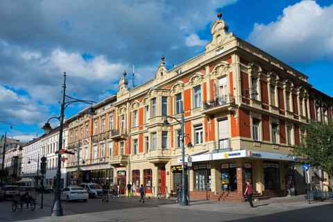 Historic Renaissance-style building in a lively street under a blue sky, Piotrkowska 70, Lódz,