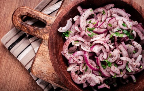 Chopped red onion, with sumac and herbs, in a bowl, pickled Spanish onion, close-up, top view