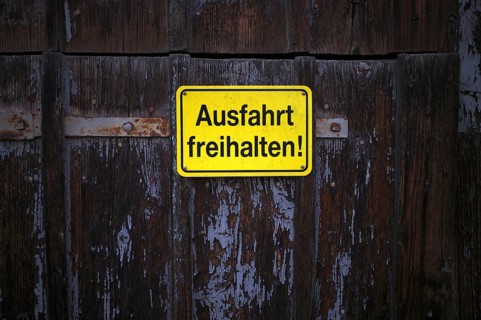 Sign AUSFAHRT FREIHALTEN, yellow, Tor tor of a wooden barn, weathered, Römerstein, Swabian Alb,