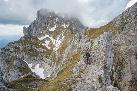 Mountaineers on a narrow hiking trail on a rocky ridge, ascent to the Maukspitze, clouds moving