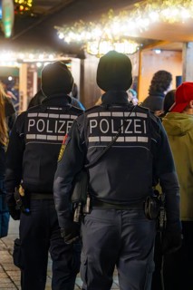 Two policemen at a busy Christmas market at night, Christmas market Ludwigsburg, Germany
