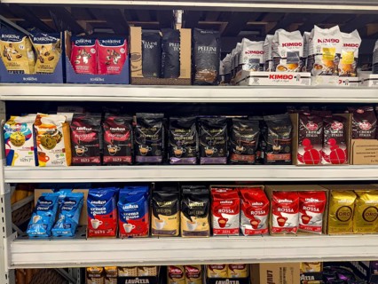 Display shelf with many different packs of unground coffee beans, Germany