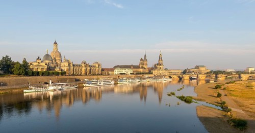 Silhouette of the Old Town with reflection in the Elbe in the morning, steamboats on the