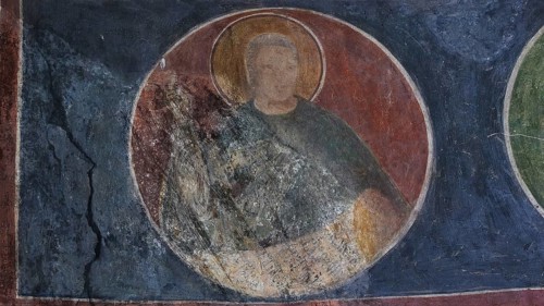 Round mural painting of a holy person in a church, partially damaged and weathered, Byzantine
