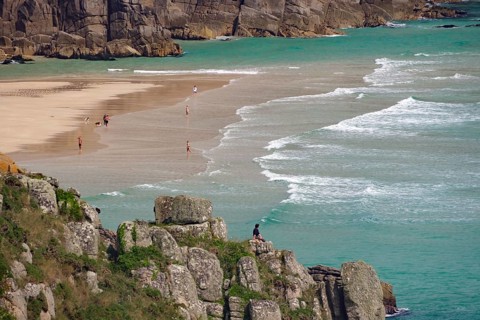Blick auf Strand zwischen Klippen mit Menschen am Ufer und türkisfarbenem Meer, Aussichtspunkt,