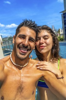 Tourists enjoying summer holidays by the pool, capturing joyful selfies against the vibrant