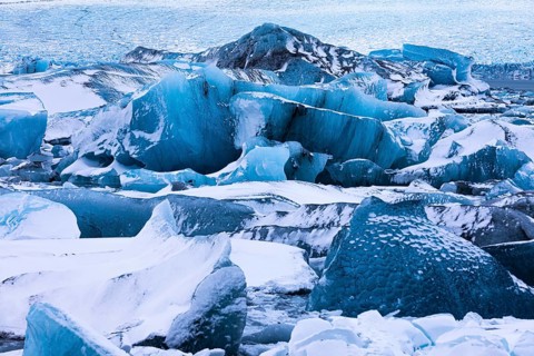 Snow-covered icebergs in the glacier lagoon Jökullsarlon, Breidamerkurjökull in the background,