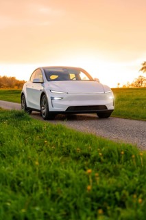 A white car parked on a country road during sunset, Tesla New Model Y, Germany