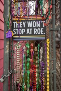 New Orleans, Louisiana - Mardi Gras beads on a fence surround a sign supporting women's right to