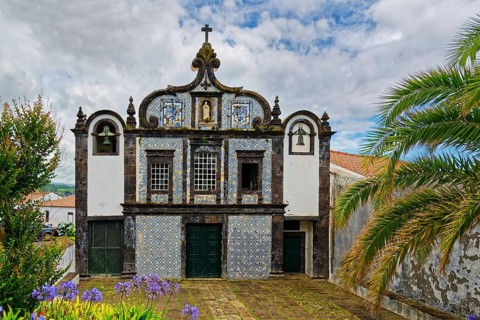 Historic church Convent of Caloura with typical tile pattern, blue and white façade and religious