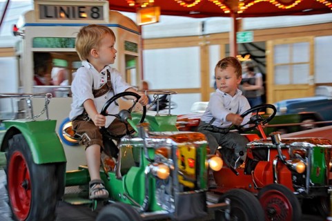Boys on tractor in carousel, old, historic Oktoberfest, Oktoberfest, Munich, Upper Bavaria,