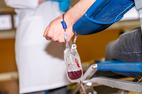Close-up rear view of a blood bag filling while extracting blood from a volunteer