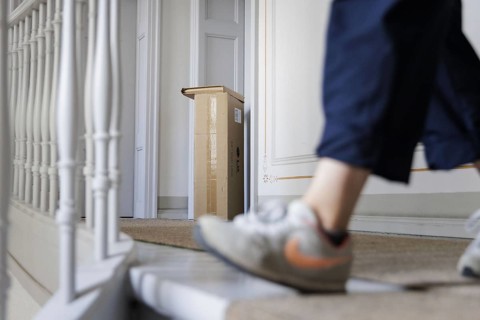 Parcel deliverer delivers a parcel to the front door in Berlin, 08.08.2024