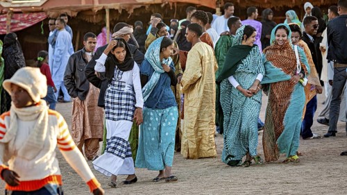 People in traditional colourful clothing enjoy a cultural festival, woman at the traditional Tuareg