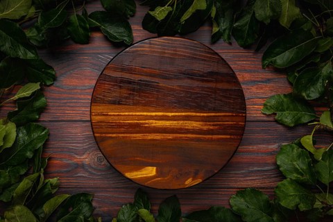 Frame of apple tree leaves on wood, round wooden board, copying room