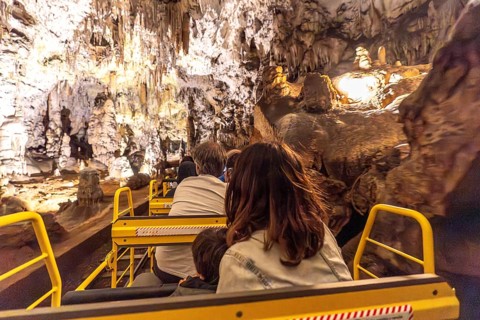 Tourists enjoying a train ride through the magnificent formations of postojna cave, a popular