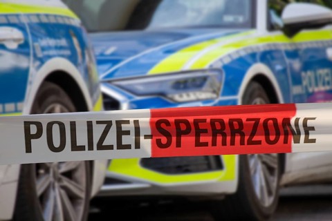 (Photomontage) Symbolic image of a police operation: police cordon in front of an emergency vehicle
